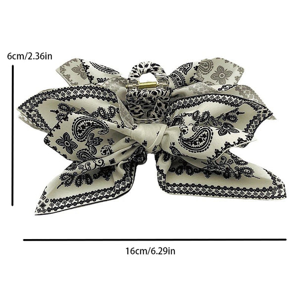 Elegant vintage hair clip featuring a floral pattern in beige and black on a white background