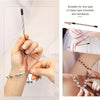 A pair of metal tools is shown applying or repairing a clasp-type bracelet on a wrist.