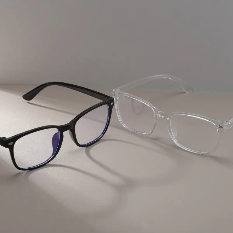 A pair of vintage square anti-blue light eyeglasses with black frames and blue lenses resting on a light surface.