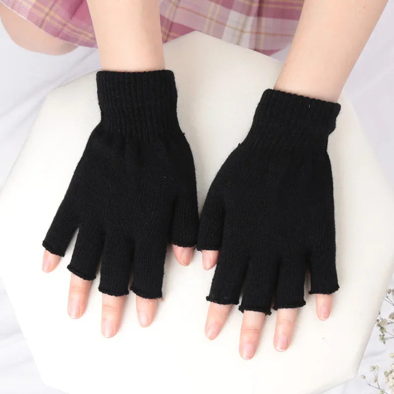 Black knit half finger gloves worn by a person against a white background.