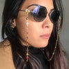 Una mujer vistiendo gafas oscuras con un collar de cuentas de cristal