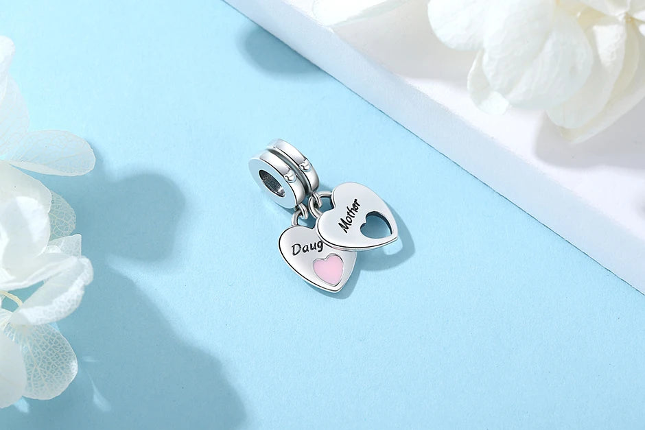 Silver pendant necklace featuring a mother and daughter heart charm on a light blue background