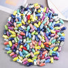 A large assortment of colorful ceramic fish charms used for DIY jewelry making