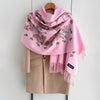 A pink luxury floral scarf draped over a beige blazer.