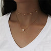 Collier minimaliste orné de petites perles, sur fond de velours noir.