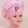 Pink satin sleep cap with a chef's hat style and a letter P embroidered on the front