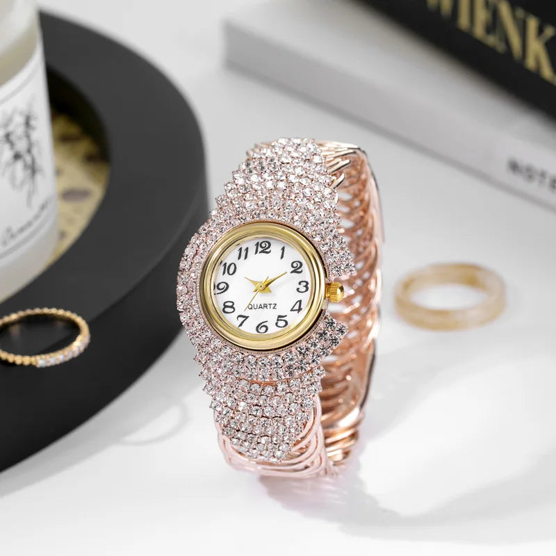 A close-up of an elegant rose gold quartz wristwatch fully encrusted with pink rhinestones.