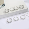 A set of silver adjustable open toe rings for women displayed on a white surface.
