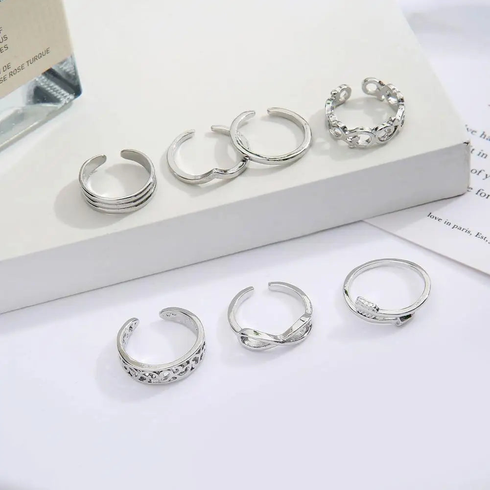 A set of silver adjustable open toe rings for women displayed on a white surface.
