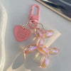 A pink jelly cartoon dog keychain with a heart tag and silver clasp.