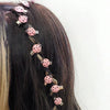 A set of ten pink ladybug hair clips adorning a dark brown hairstyle.