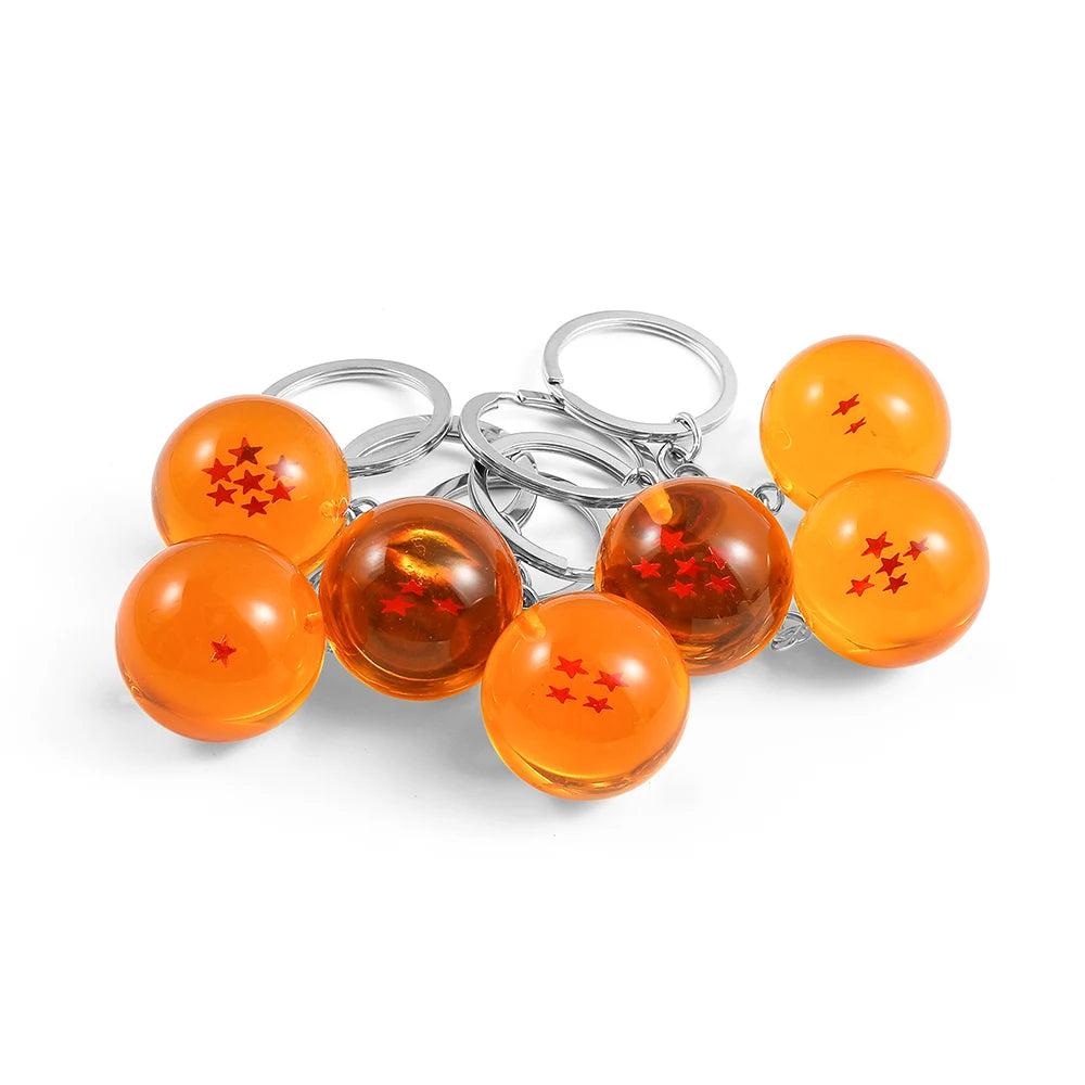 A set of round, orange-colored anime star keychains attached to silver split rings.