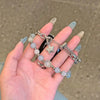 A hand holds a handmade transparent blue double chain watch strap featuring round beads and a star charm.