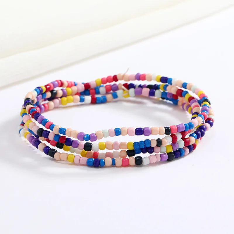 Una pulsera hecha de cuentas de colores en tonos de rosa, azul y púrpura.