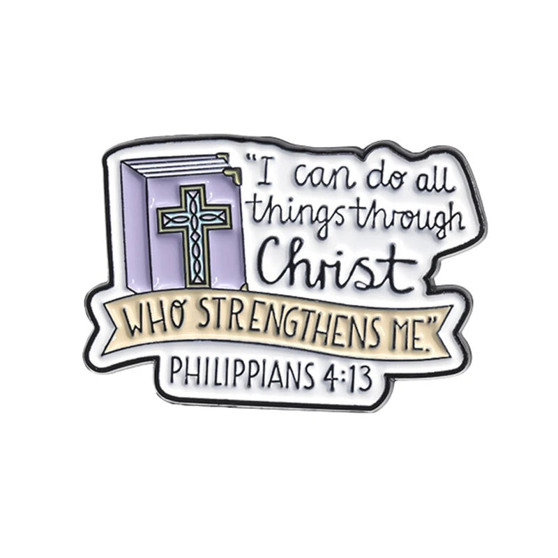 Broche émaillée représentant un livre violet avec une croix et le texte "Je peux tout par Christ Philippiens 4:13"