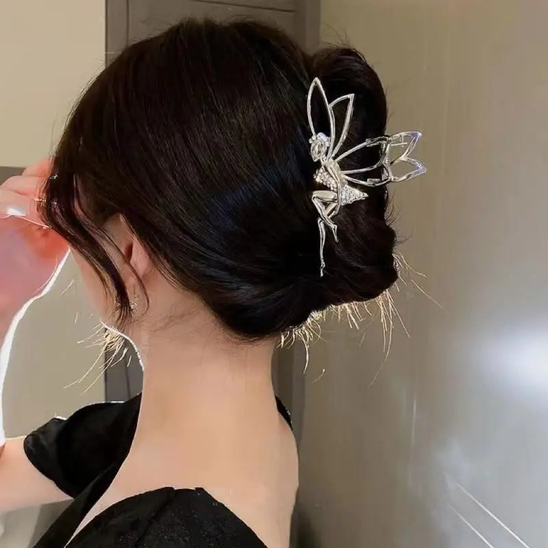 A close-up of a woman's dark hair styled in an updo with a silver rhinestone butterfly hair clip.