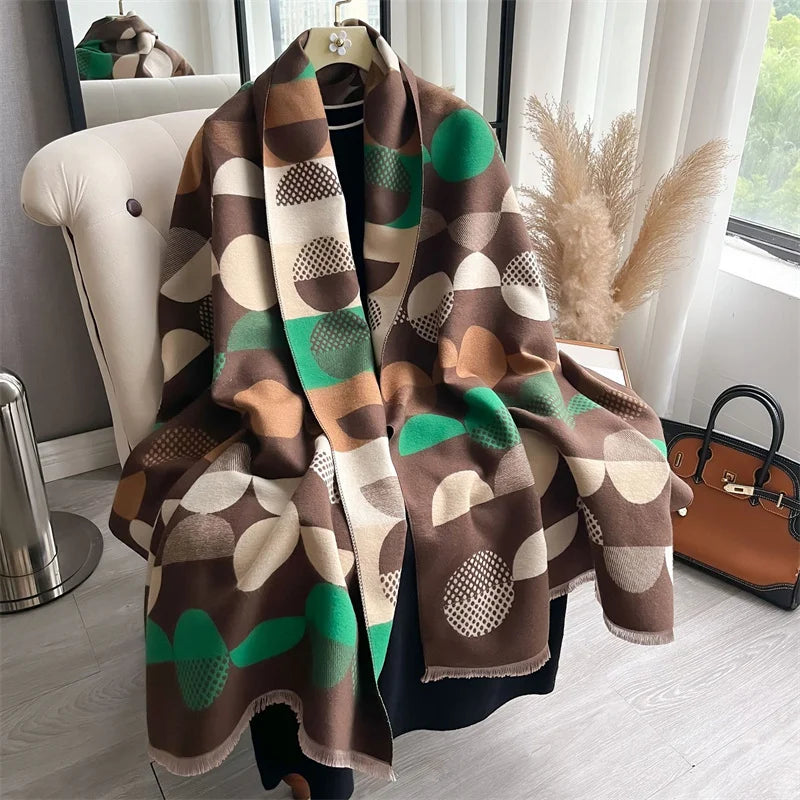 A brown and green plaid cashmere scarf draped over a hanger in a bright room.