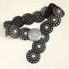 A black denim belt featuring silver studs and decorative metal discs.