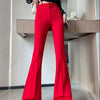 A woman models high-waist red flare skinny pants paired with a black top and black sandals.