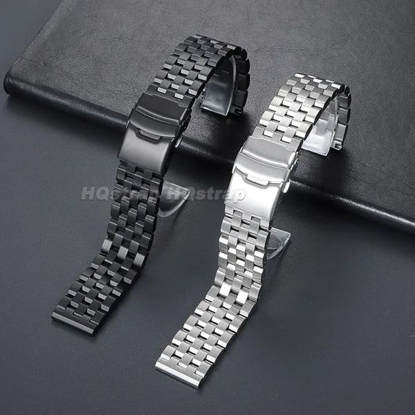 Deux bracelets de montre en acier inoxydable réglables avec une finition texturée, présentés sur une surface sombre.