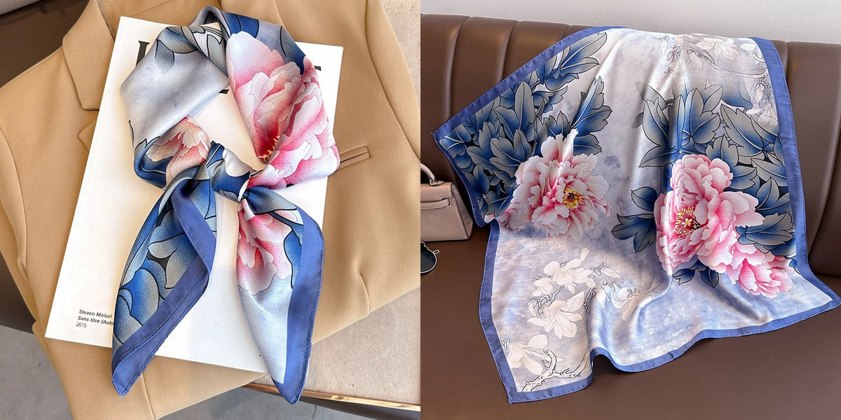 A light blue floral print silk scarf tied in a bow displayed on a tan blazer.