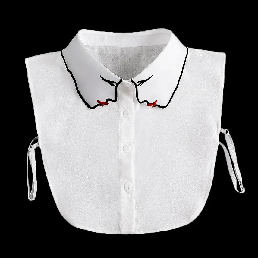 White blouse with a fashionable false collar neckline featuring black trim and red accents.