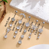 A set of five gold stainless steel dangled belly button rings with various gemstone sizes displayed on a light background.