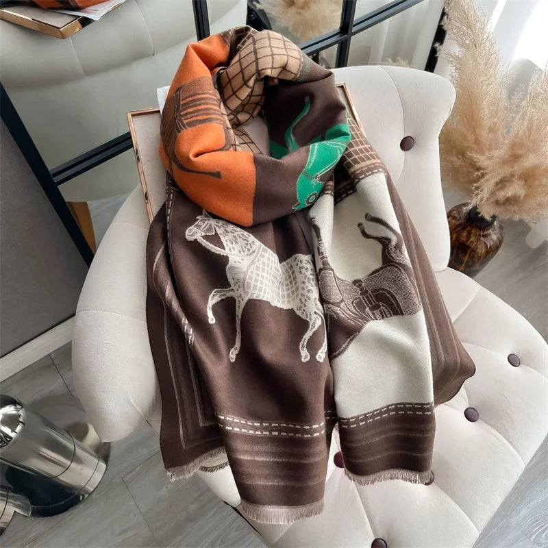 A brown and orange plaid cashmere scarf and shawl wrap draped over a white chair.