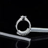A silver ring sizer tool set featuring a ring and a corresponding adjustable sizing tool on a reflective black surface.
