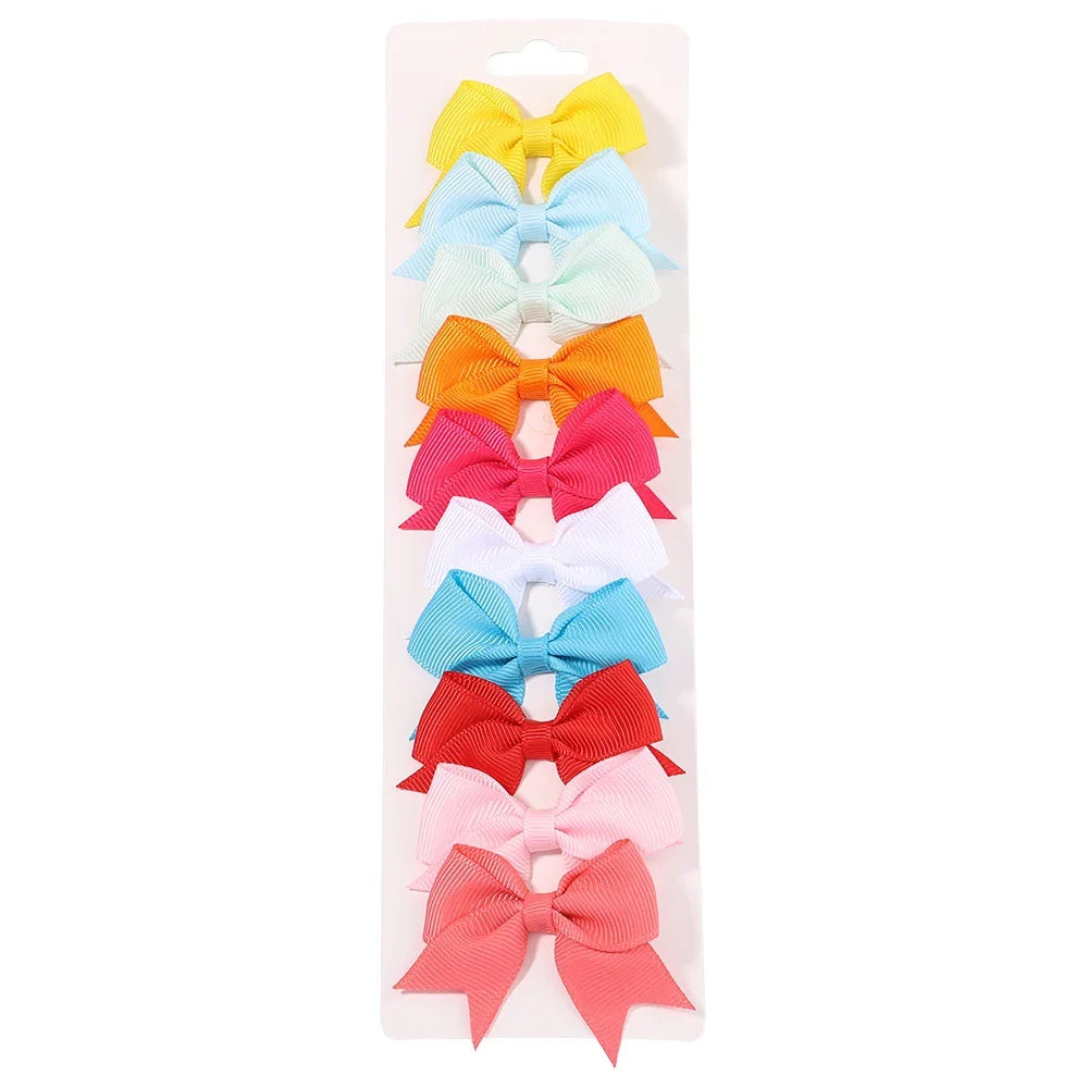 A collection of colorful handmade ribbon bow hair clips for kids in yellow, light blue, mint green, orange, pink, and blue.