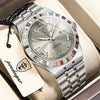 A silver men's luminous quartz wristwatch with a metal bracelet and a leather tag is displayed in a box.