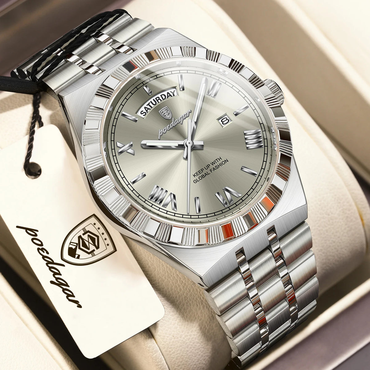 A silver men's luminous quartz wristwatch with a metal bracelet and a leather tag is displayed in a box.