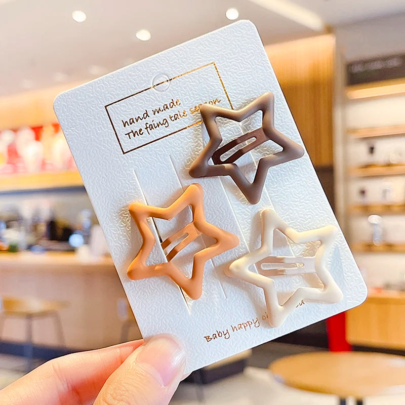 A set of vintage frosted geometry hair clips in various shades of beige and brown displayed on a white card.