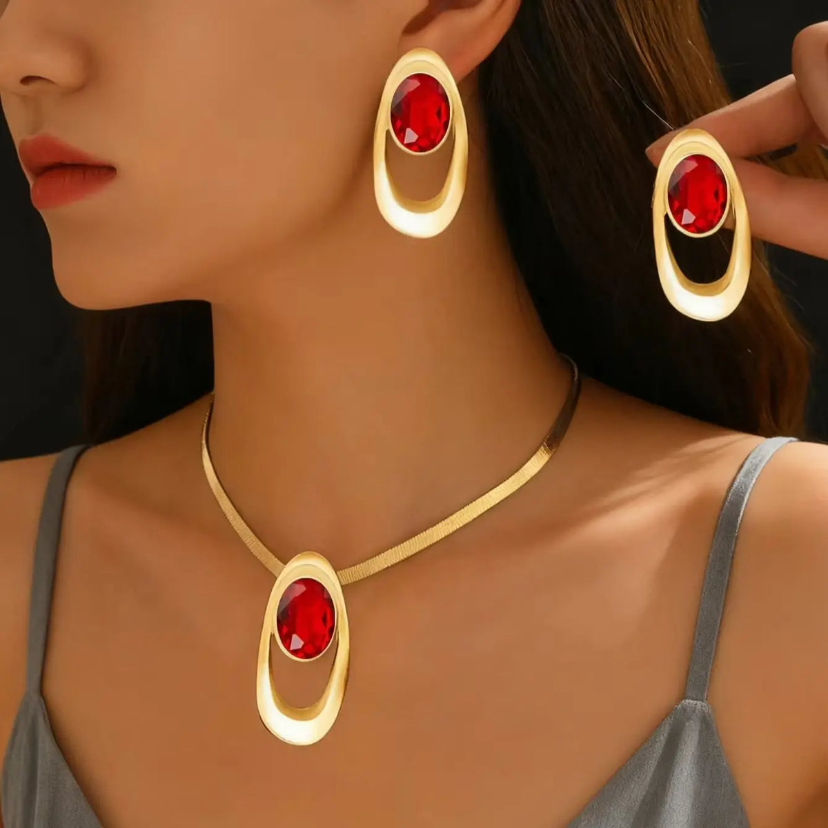 Gold and red oval three-ring buckle necklace set worn by a woman