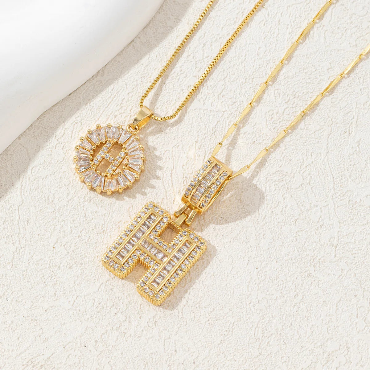 Gold-toned necklace set featuring CZ crystal pendants shaped like the letters H and O.
