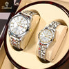 A pair of stainless steel couple watches displayed on light-colored leather pads.
