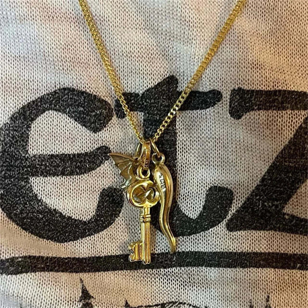 Gold plated butterfly key pendant charm hanging from a delicate gold chain.