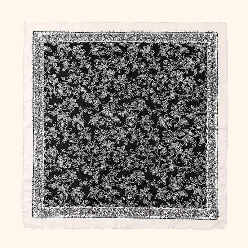 Schwarz-weißes Blumenmuster auf einem weißen Stoffquadrat.
