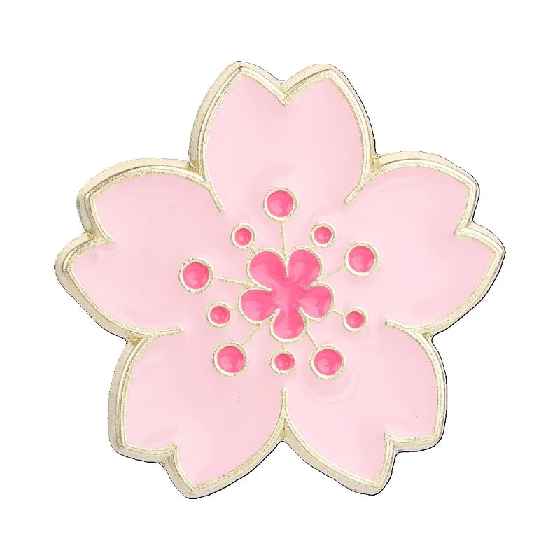 A delicate pink enamel flower brooch featuring a central cluster of pink petals and stamens.