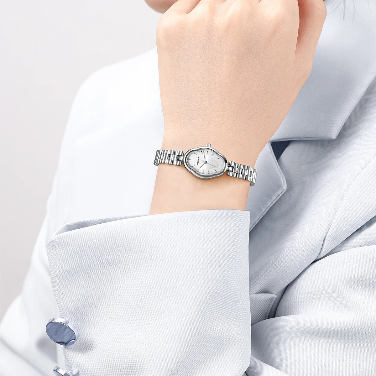 Gros plan d'une femme portant une élégante montre-bracelet en quartz en acier inoxydable à son poignet, visible contre un cos