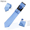 Corbata de seda a rayas azul claro con una flor boutonnière azul y pañuelo de bolsillo a juego.