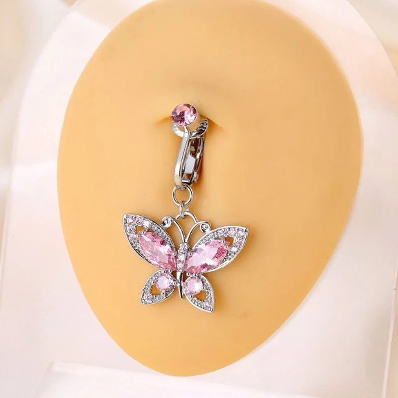 Silver butterfly belly button ring with pink gemstone detail displayed on a light yellow background.