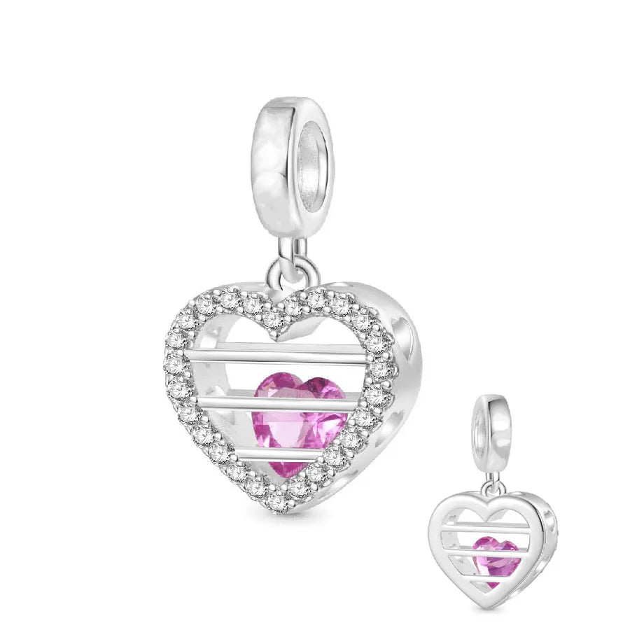 Colgante de corazón plateado con piedras brillantes y detalle animal.