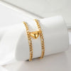 A gold-colored stainless steel heart magnetic bracelet set for couples displayed on a white surface.