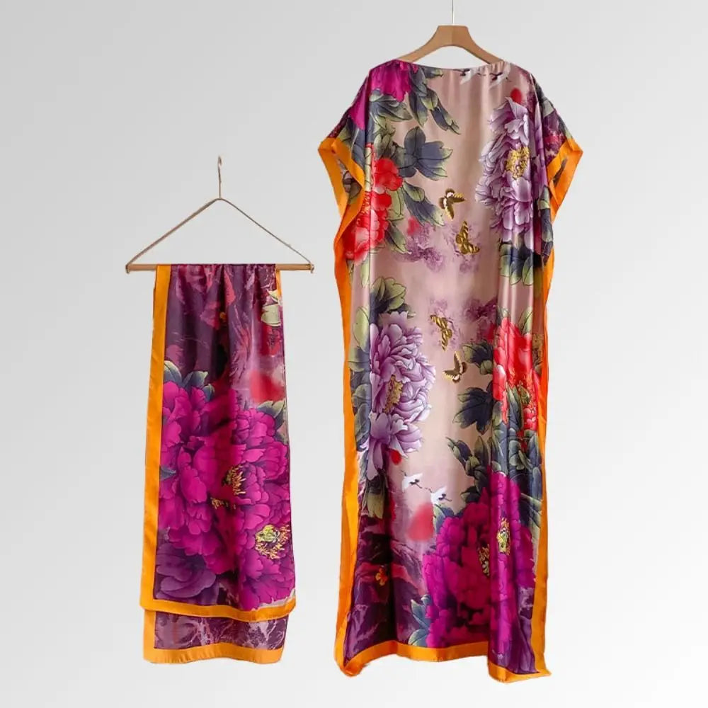 Un long châle cape fluide avec un imprimé papillon floral flamboyant dans des tons de rose, violet et vert.