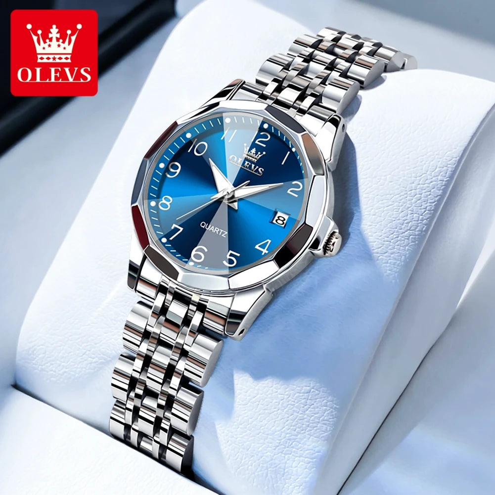 Silberfarbene Quarzuhr mit blauem Zifferblatt und Metallarmband auf weißem Tuch.
