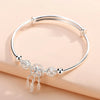 A silver bell bangle bracelet for women shown against a light background.