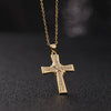 A dainty gold cross charm necklace with small diamonds hanging from a delicate chain.