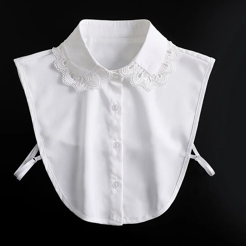 White blouse with a detachable lace false collar and tie-back details.