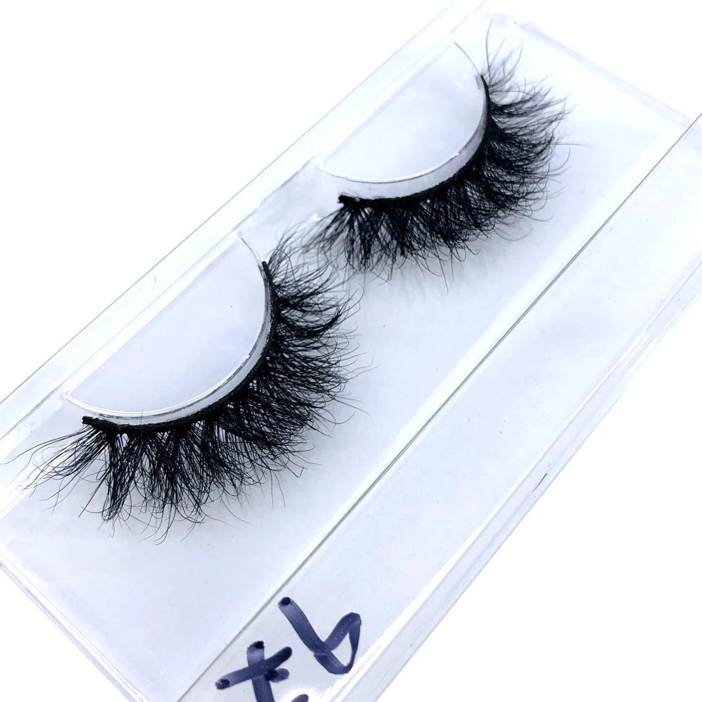 A pair of black natural mink false eyelashes displayed on a clear plastic card.